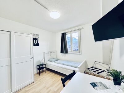 Möbliertes Einzelzimmer in einem Monteurzimmer in Balsthal mit Bett, Schrank und Tisch
