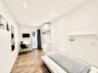 Einzelzimmer Standard in Oensingen mit Bett, Schreibtisch und Kleiderschrank